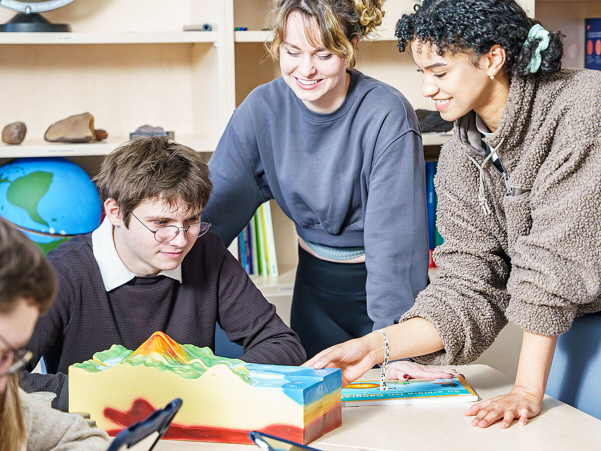Studierende schauen sich im Seminar verschiedene Unterrichtsmaterialien an.