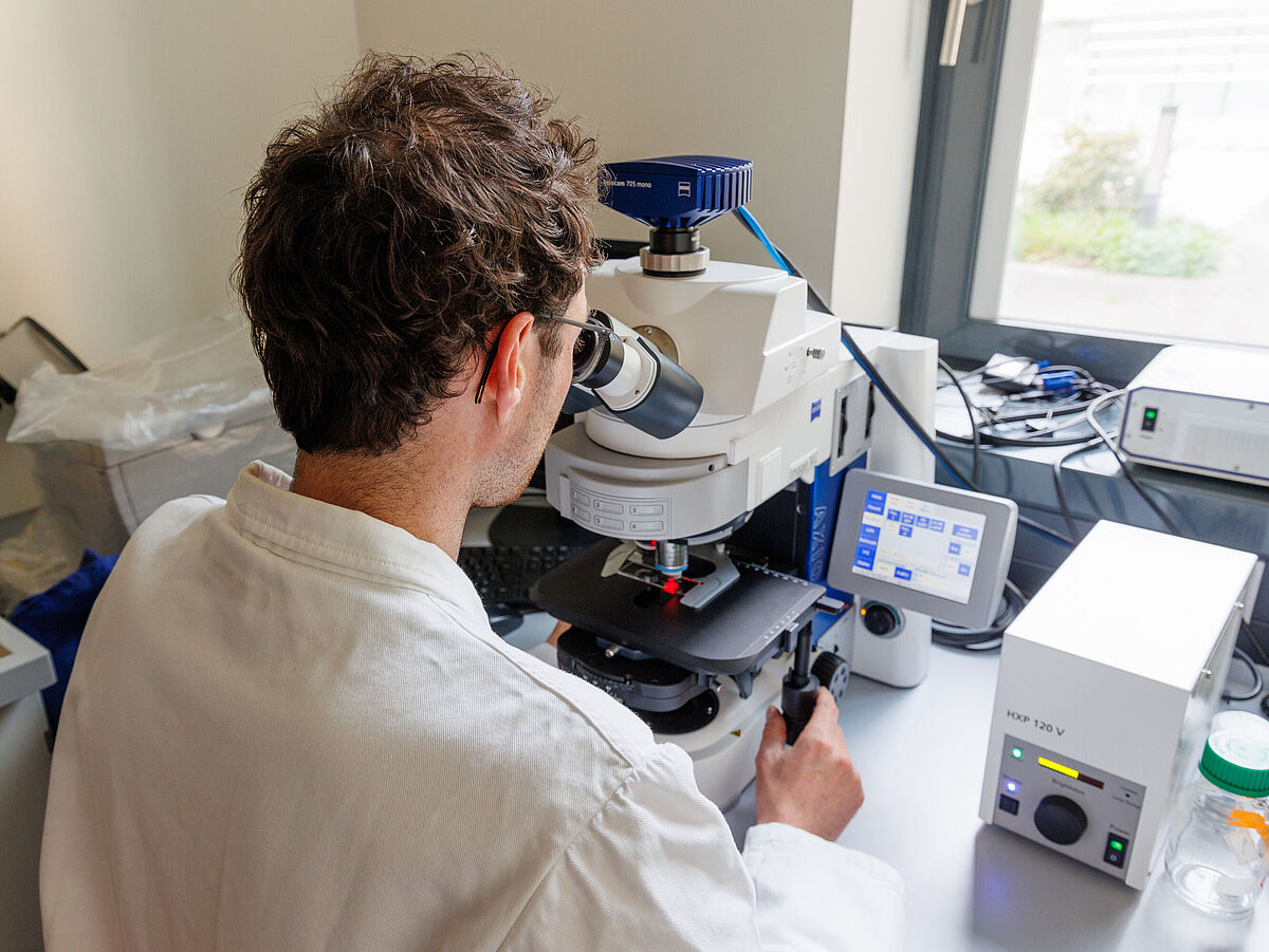 Ein Mann sitzt im Labor und führt Untersuchungen durch.